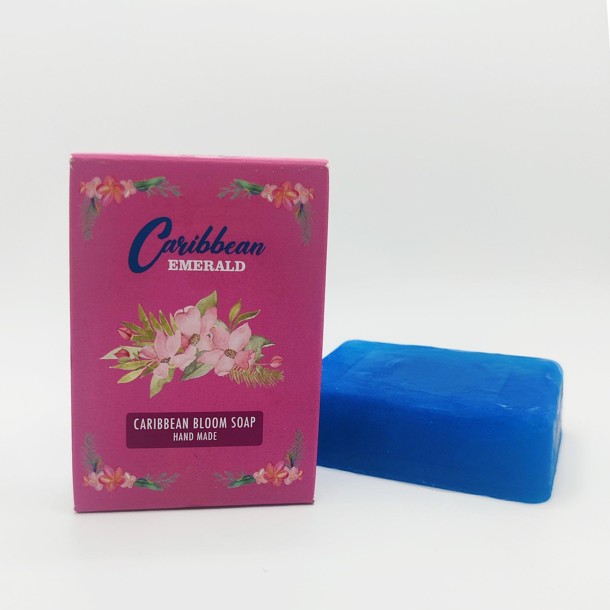 Caribbean Bloom handmade blue soap bar next to its pink floral packaging box.