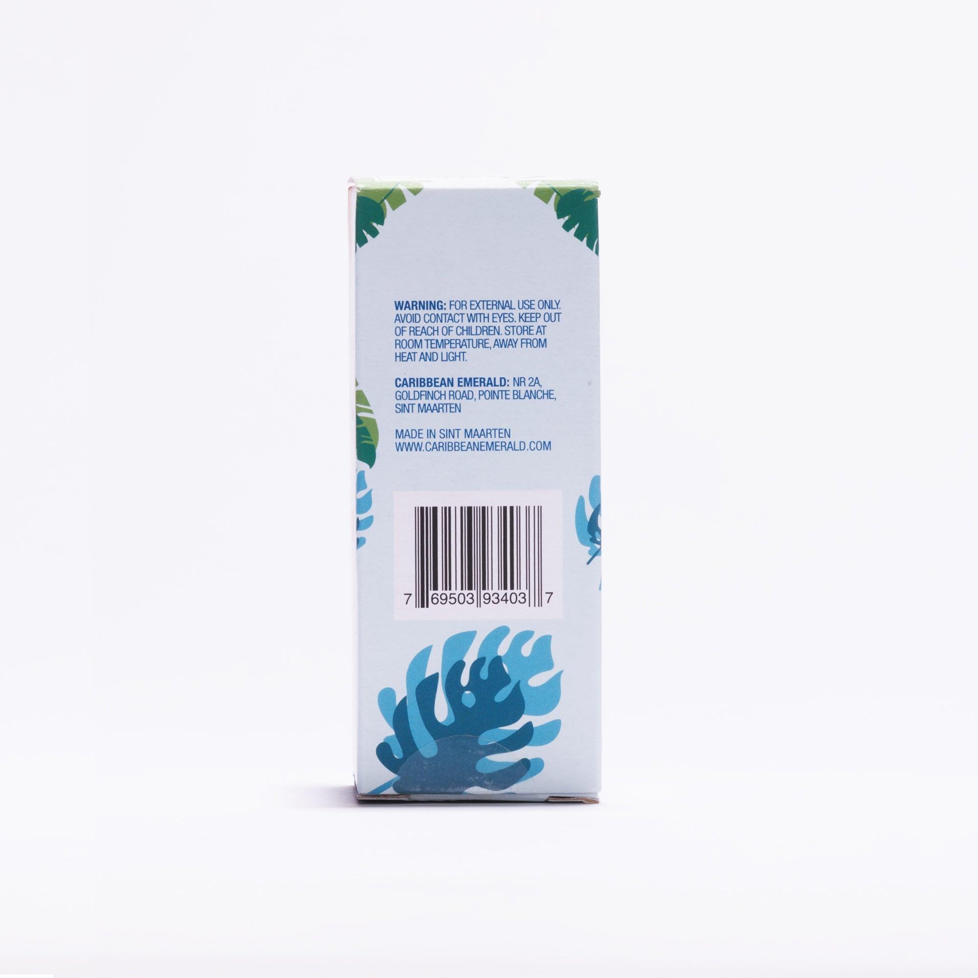 Back of the Caribbean Emerald Elastin Serum box displaying warnings and ingredients, with tropical leaf design on a white background