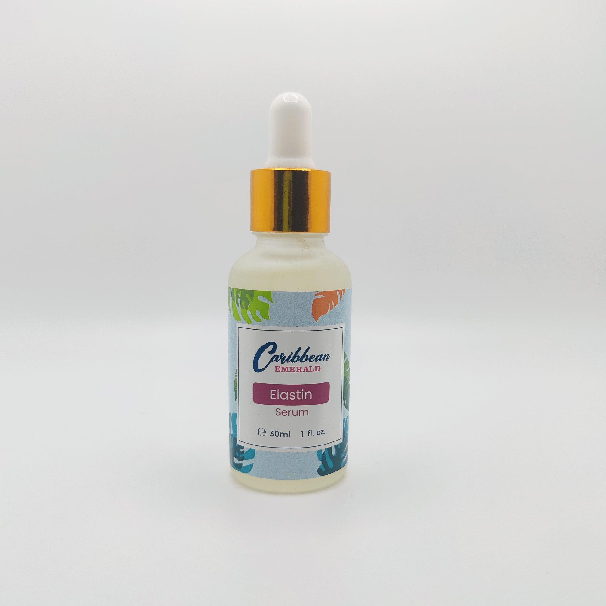 Front view of the Caribbean Emerald Elastin Serum box with tropical leaf design, placed on a white surface with green leaves nearby