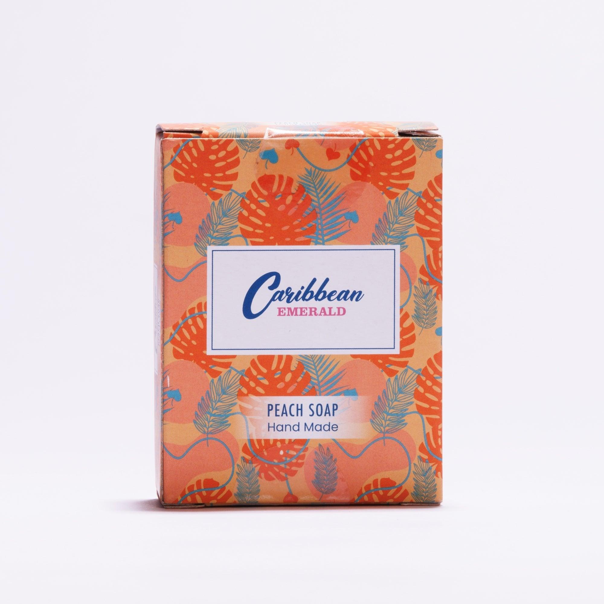 Handmade peach soap in orange tropical leaf patterned packaging.